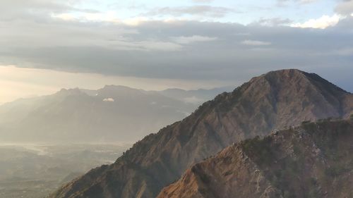 Scenic view of mountains against cloudy sky