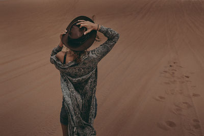 High angle view of woman standing on sand