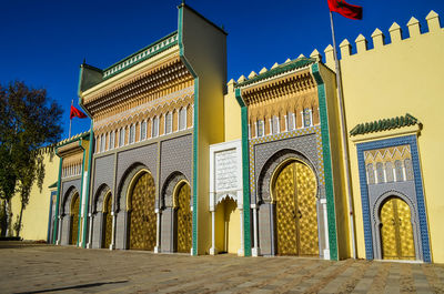 Low angle view of illuminated building against clear blue sky