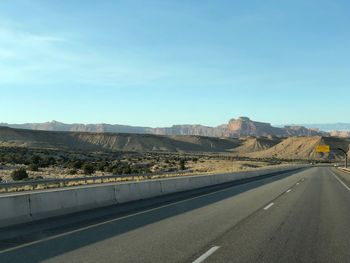Road leading towards mountains against sky