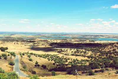 Scenic view of field and lakes against sky