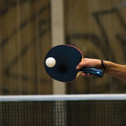 Cropped hand of woman playing table tennis