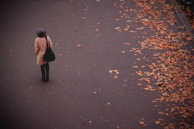 Full length of woman walking on autumn leaves