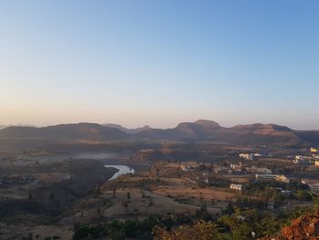 High angle view of river and mountains against clear sky