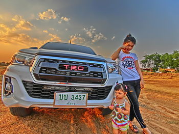 Portrait of smiling young woman standing on road against sky