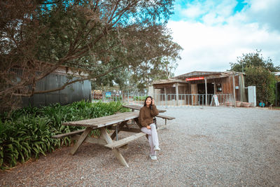 Side view of woman sitting on field