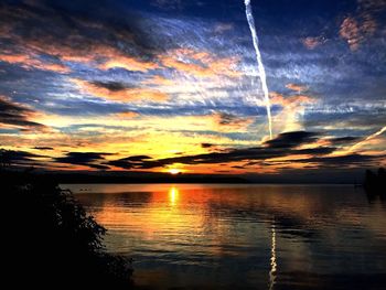 Scenic view of dramatic sky over lake during sunset