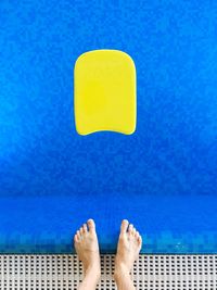 Low section of woman standing on swimming pool