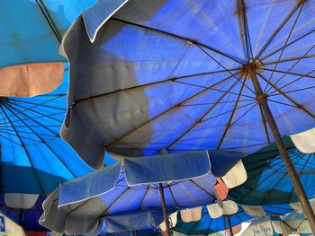 Low angle view of parasol against blue sky