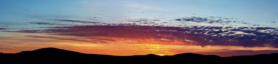 Scenic view of silhouette mountains against sky at sunset