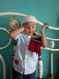 Boy wearing religious cap against wall
