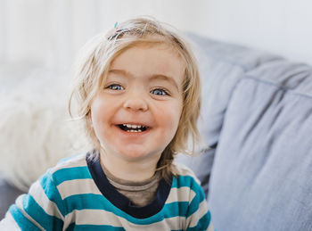 Portrait of smiling girl on sofa at home