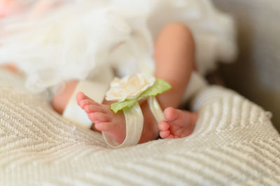 Low section of baby girl lying at home