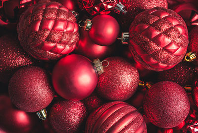 High angle close up of a variety of red christmas ball ornaments.