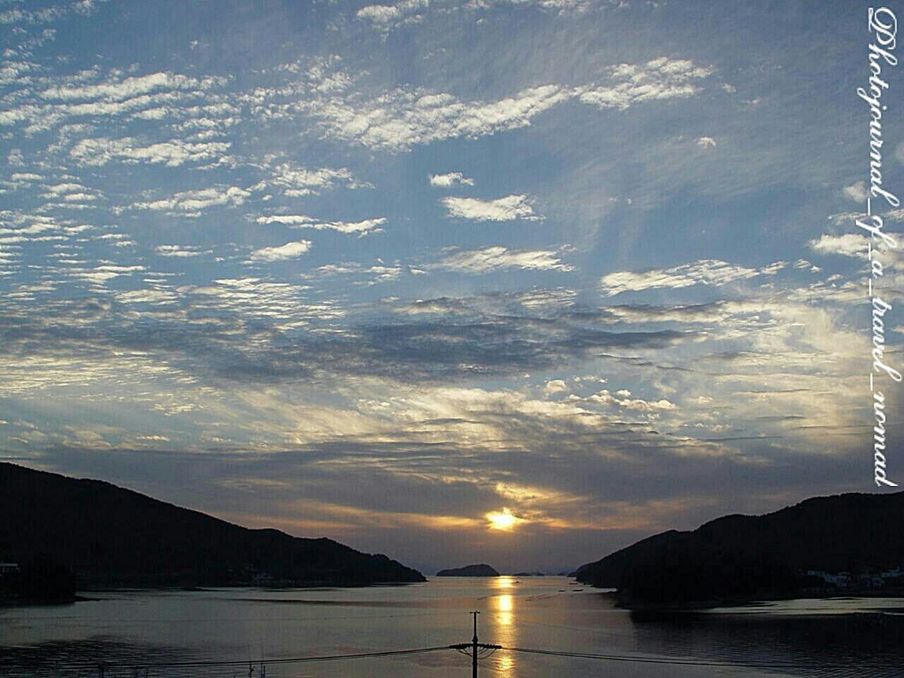 SCENIC VIEW OF SEA AGAINST CLOUDY SKY AT SUNSET