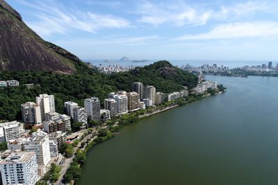 High angle view of city by sea against sky