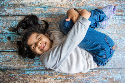 High angle view of girl lying on floor at home