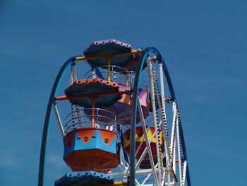 Low angle view of ferris wheel against blue sky