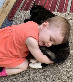 High angle view of siblings lying on floor