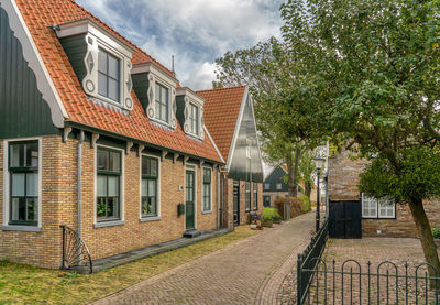 Residential buildings by street against sky