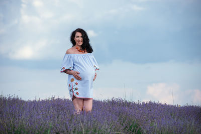 Full length of woman standing on field against sky