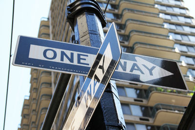 Low angle view of road sign against built structures