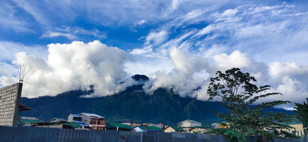 Panoramic shot of buildings and mountains against sky
