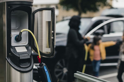 Cable connected to electrical outlet at car charging station