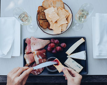 Cropped hand of person having cheese on table