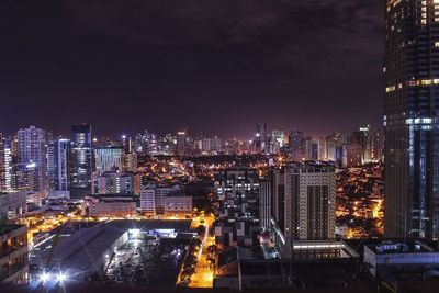 High angle view of illuminated buildings against sky at night