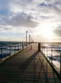 Pier on sea at sunset