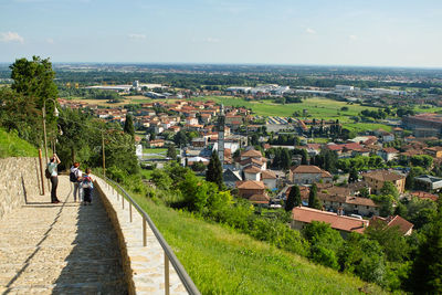 High angle view of people on sea by buildings against sky