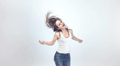 Portrait of a smiling young woman against white background