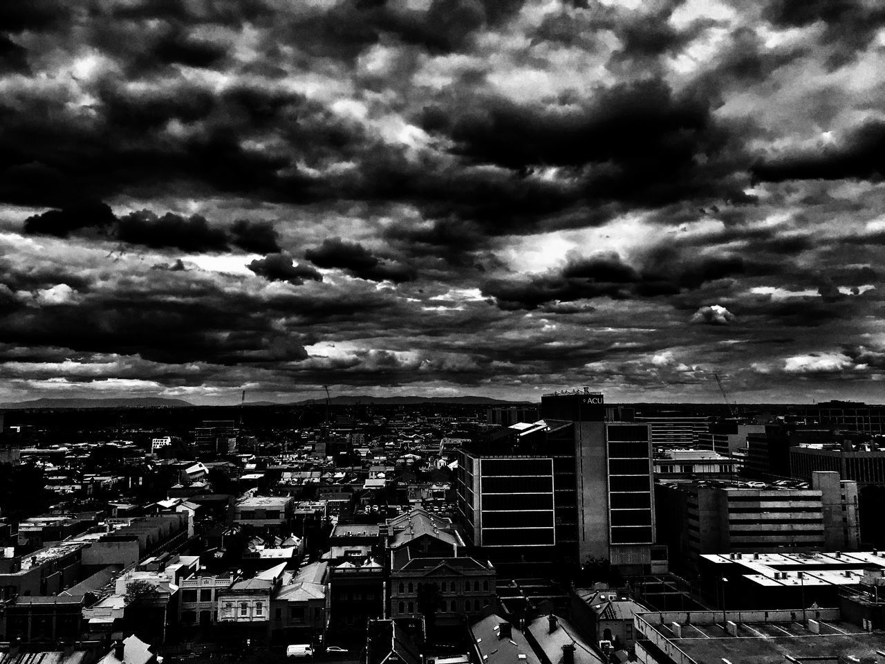 BUILDINGS IN CITY AGAINST STORM CLOUDS