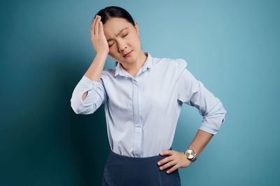 Mid adult man standing against blue background