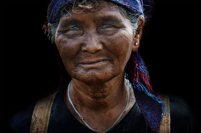 Portrait of mid adult woman against black background