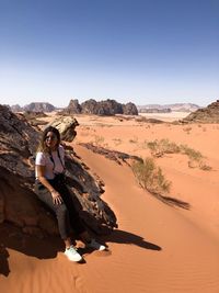 Full length of woman on desert with dunes against clear sky travel photography 