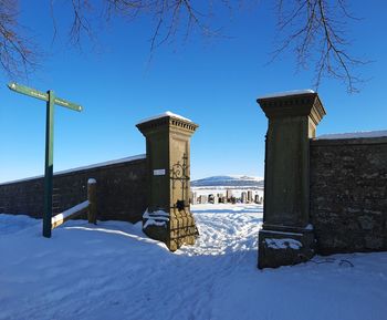 Built structure on snow covered field against sky