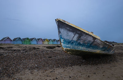 Boat moored on beach against clear sky