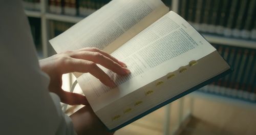 Midsection of man reading book