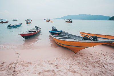 Boats moored on sea against sky