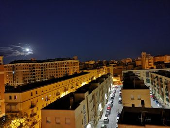 High angle view of illuminated buildings against sky at night