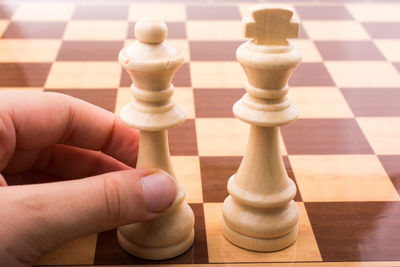 Close-up of hand holding chess piece