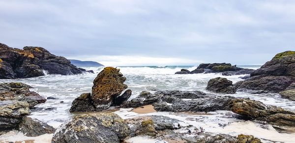 Rocks on beach against sky