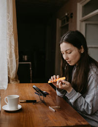 Close-up of young woman using mobile phone while sitting at home