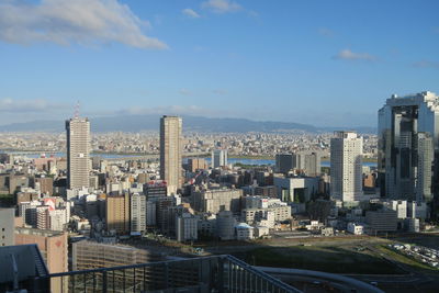 Aerial view of buildings in city against sky