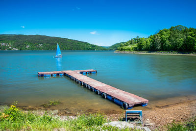 Wooden jetty on the shore of the zywieckie lake. mountains covered with the forest 