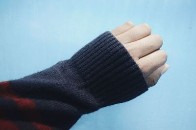 Close-up of man hand against blue background