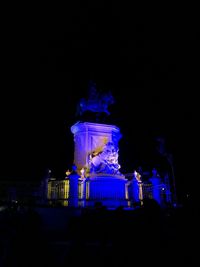 Statue of illuminated fountain at night