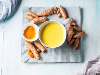 Directly above shot of turmeric milk with ginger on table